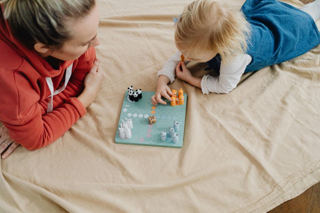Mother and daughter enjoying a board game indoors, fostering connection and fun.